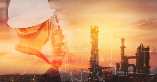 Engineer with safety helmet with oil refinery industry plant background