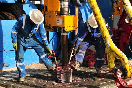 workers operating a drilling rig